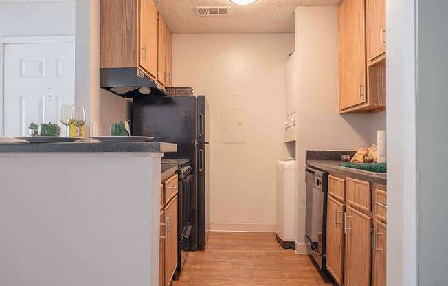 a kitchen with wooden cabinets and a black refrigerator