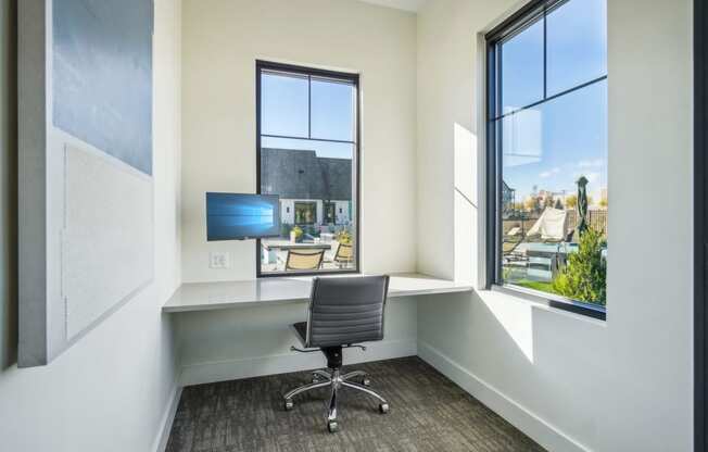a home office with a desk and a chair and a window