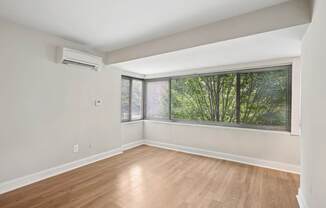 A room with a window and wooden flooring.