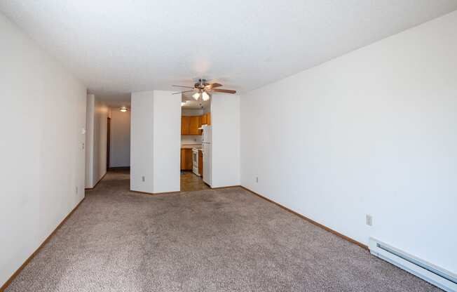 a spacious living room with carpet and a ceiling fan. Fargo, ND Westview Towers Apartments