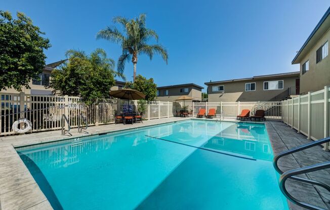 Canoga Park Luxury Apartments - Large Swimming Pool Surrounded by Lounge Chairs and Tables