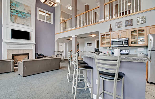 A welcoming resident lounge here at Arbor Ridge featuring bright windows, café-style tables, and a convenient workspace. Warm wood trim and comfortable seating create a relaxed, inviting space for work or socializing.