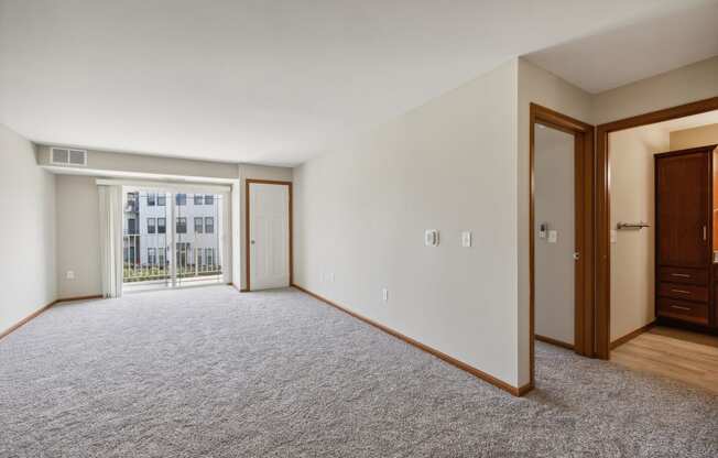 an empty living room with a door to a balcony