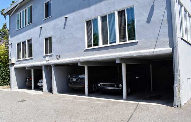 a white building with cars parked in a parking garage