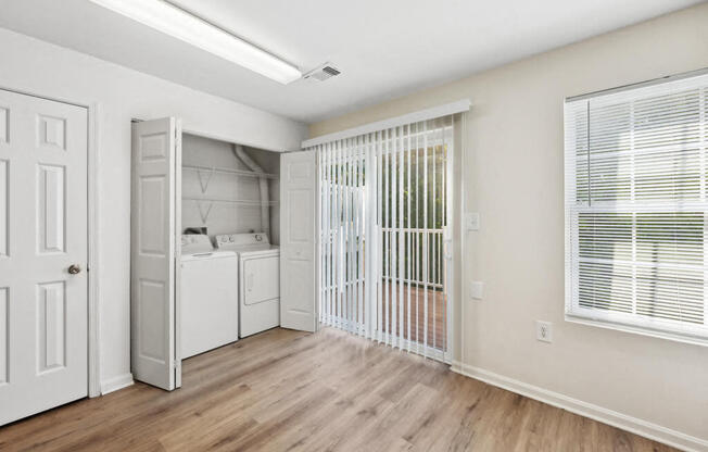 an empty room with a laundry room and a closet