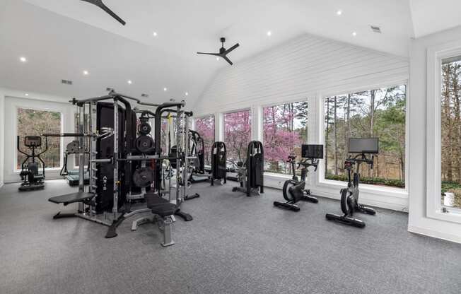 a gym with a lot of exercise equipment and windows