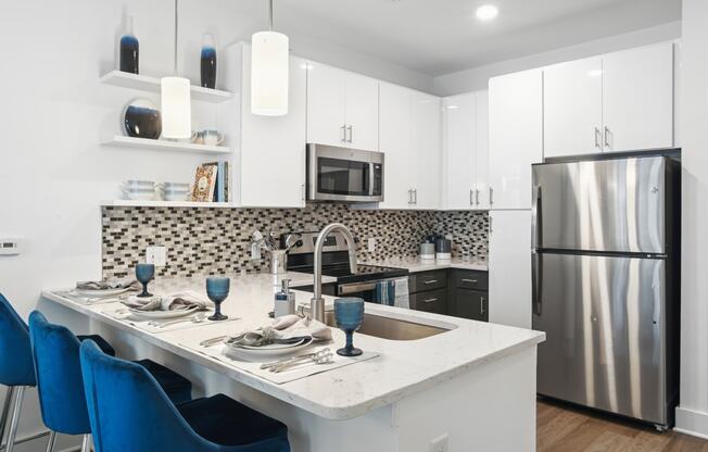 a kitchen with a island and a stainless steel refrigerator at Link Apartments® Mint Street, Charlotte, NC, 28203