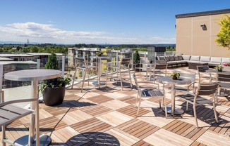 A rooftop patio with tables and chairs at west parc apartments near portland and beaverton.