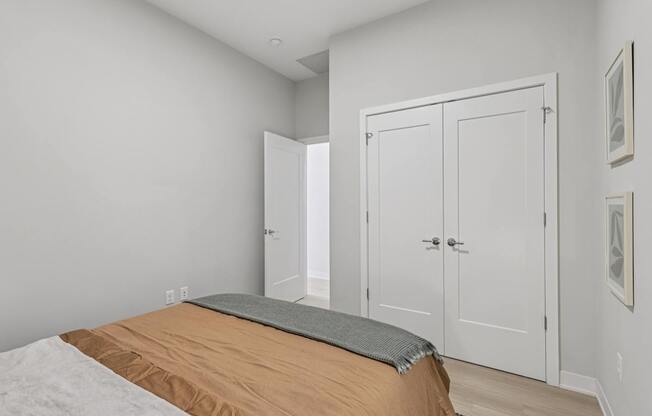 A bedroom with a bed, a mattress, and two white doors.