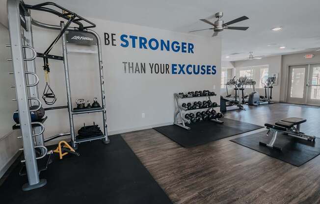 A gym with a sign that says Be Stronger Than Your Excuses