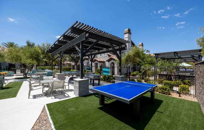 clubhouse with ping pong table and patio with chairs and a pergola