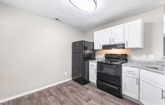 the kitchen of our studio apartment atrium with black appliances and white cabinets