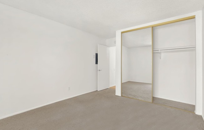 an empty room with white walls and a sliding glass door at Casa Del Amo Apartments, Torrance, CA 90505