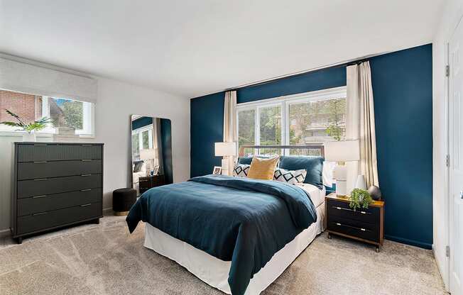 a bedroom with blue walls and a bed with a blue comforter