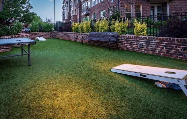 Outdoor games in the grass area, showing cornhole game.
