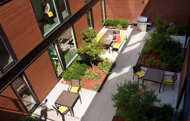 Exterior view of community. Beautiful landscaping with seating areas, a community grill and pathways to the building.at 19th & Mercer, Seattle