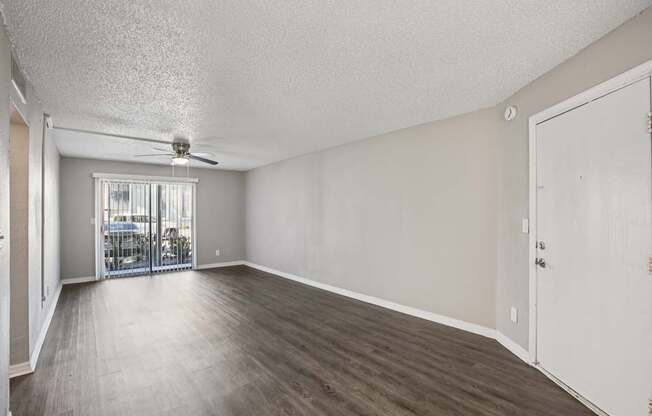 A room with a sliding glass door leading to a balcony.