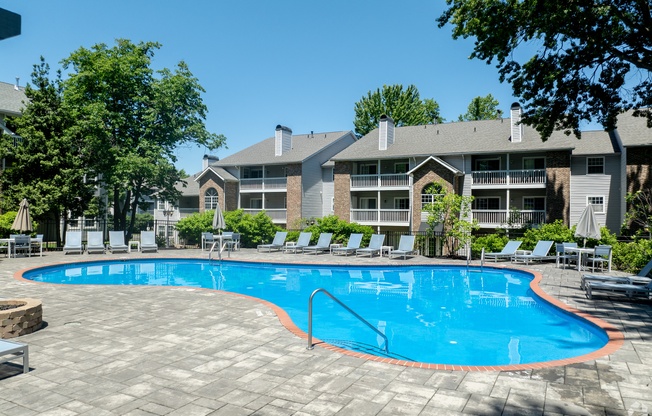 a large swimming pool in front of an apartment building