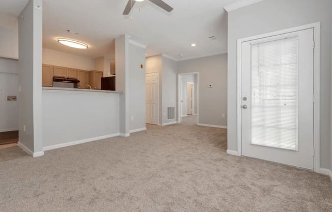 A spacious room with a ceiling fan and carpeted floor.