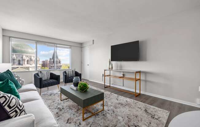 a living room with white walls and a large window