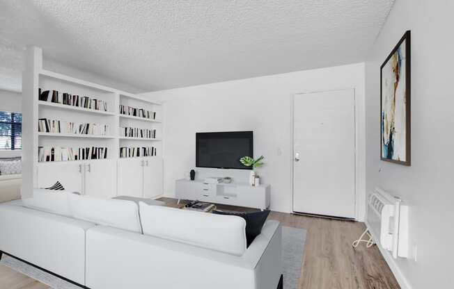 a living room with a white couch and a tv