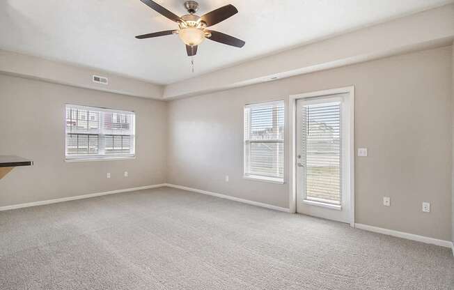 An end style living room with a ceiling fan and windows at Lynbrook Apartments and Townhomes, Elkhorn, NE, 68022
