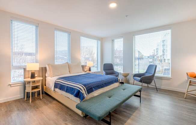 a bedroom with a bed and three oversized windows at Marina Square, Bremerton
