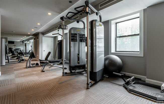 a gym with exercise machines and weights on the floor