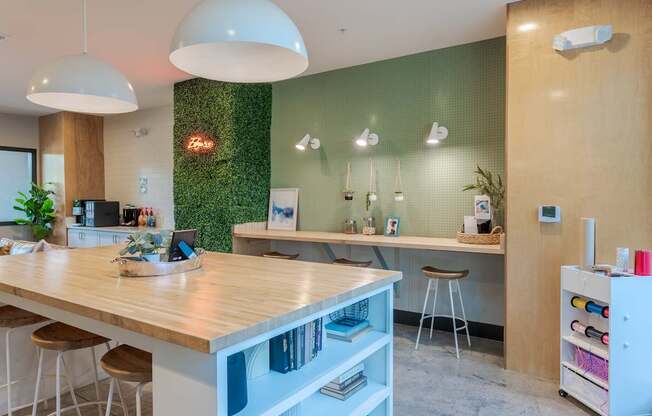 A modern kitchen with a wooden counter and white stools.
