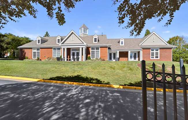 A red brick building with a black fence in front.