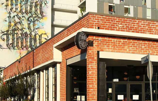 A storefront with a large mural on the wall above it.