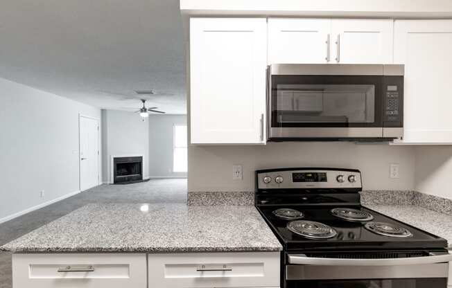 a kitchen with white cabinets and a black stove top oven