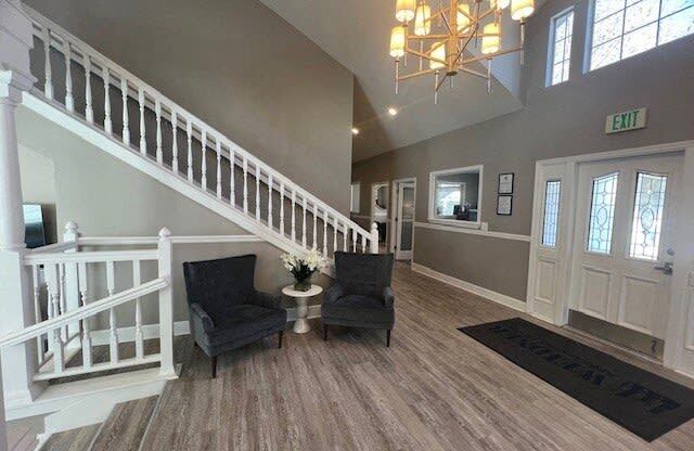 a living room with two chairs and a staircase