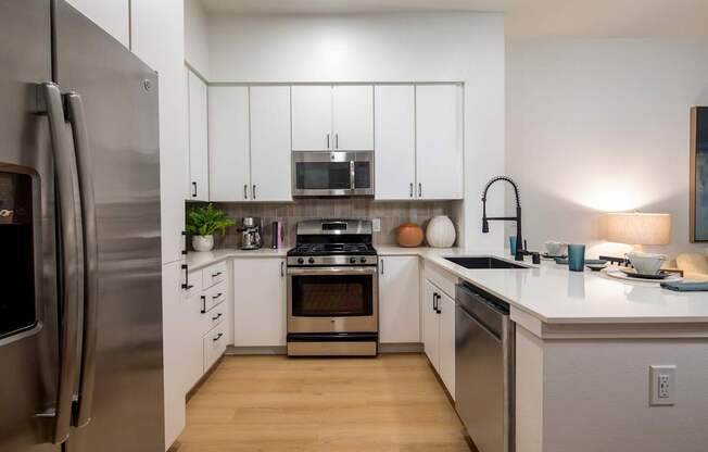 A modern kitchen with stainless steel appliances and white cabinets.