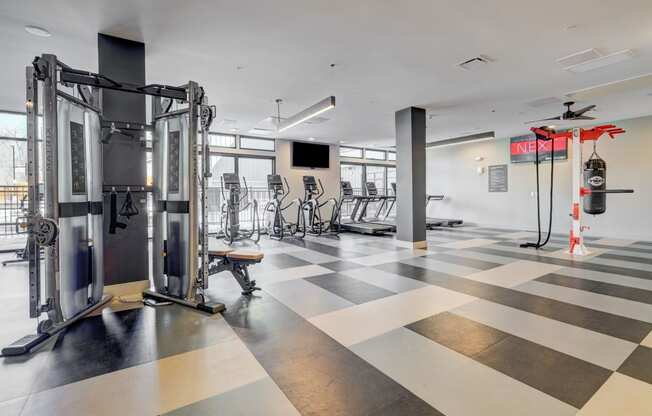 a gym with a checkered floor and weights and cardio equipment