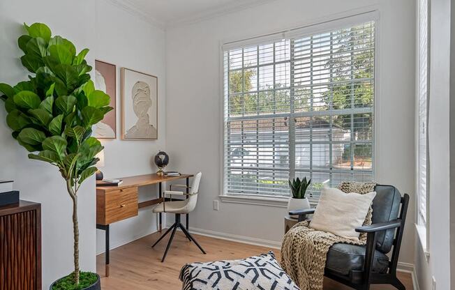 a living room with a couch and a desk and a window