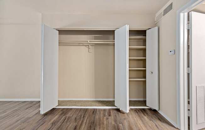 an empty bedroom with an open closet