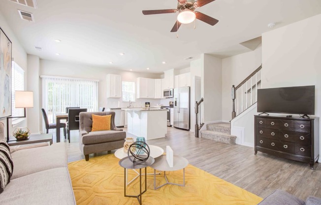 a living room and kitchen with a ceiling fan