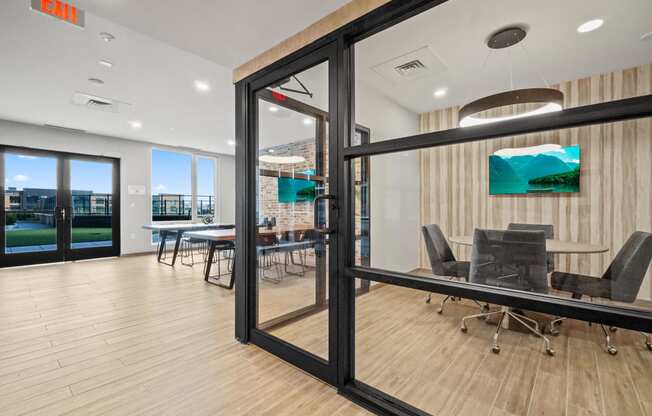 a conference room with glass doors and a table with chairs