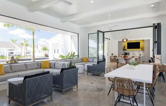 Open concept resident space with a white dining table and rattan chairs at Odyssey, Florida