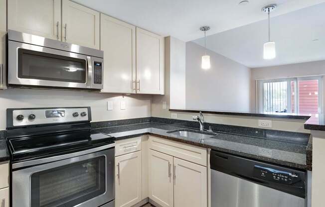 A kitchen with a stainless steel oven and microwave.