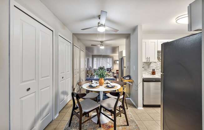 an open kitchen and dining room with a table and chairs at Town & Country Apartments - Wixom, MI, Wixom