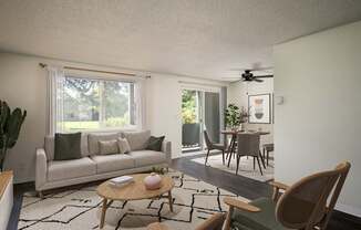 A living room with a couch, a chair, a table, and a ceiling fan.