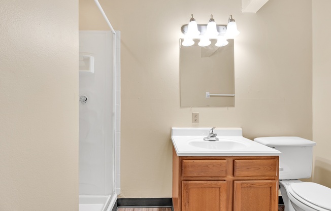 A bathroom with a white sink and toilet.
