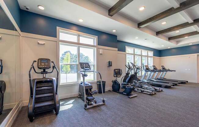 A gym with treadmills, elliptical machines, and other exercise equipment.