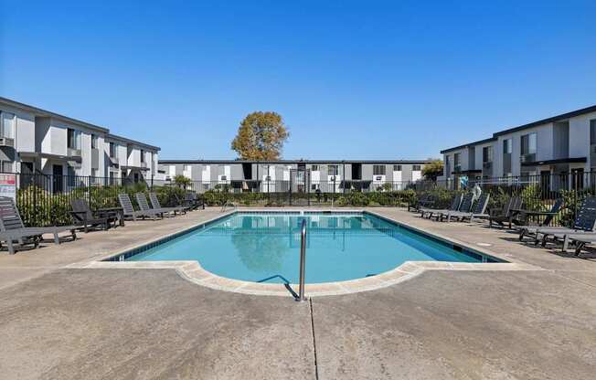 A swimming pool in front of apartment buildings.