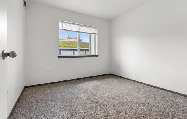 A room with a window overlooking a building outside.