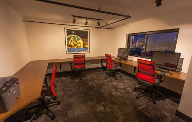 Coworking room with red chairs and city views at Archer Tower in Denver, CO
