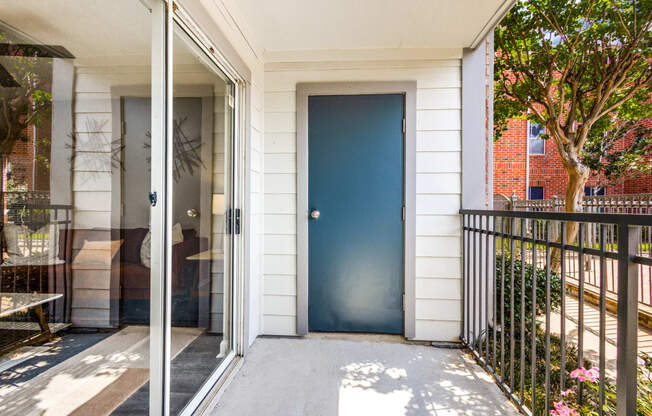 the front door of a white house with a blue door