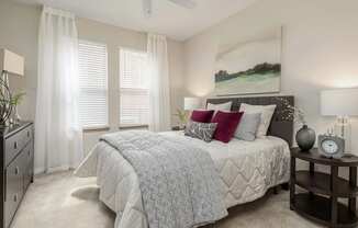 A bedroom with a large bed and a ceiling fan.